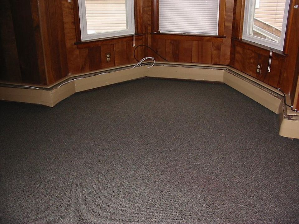 Carpeted living room with bay window.