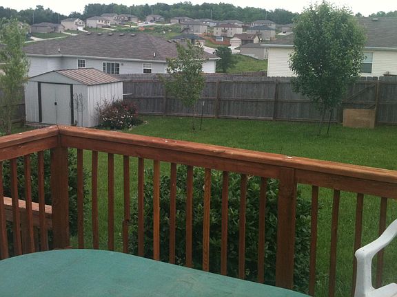 View out back and storage shed with mature trees/plants