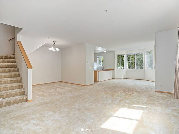 Step onto a tile landing with soft carpeted living room