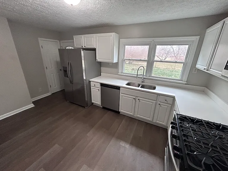 Quartz countertops and plenty of cabinets and sunlight in this immaculate fully updated kitchen with a double door refrigerator