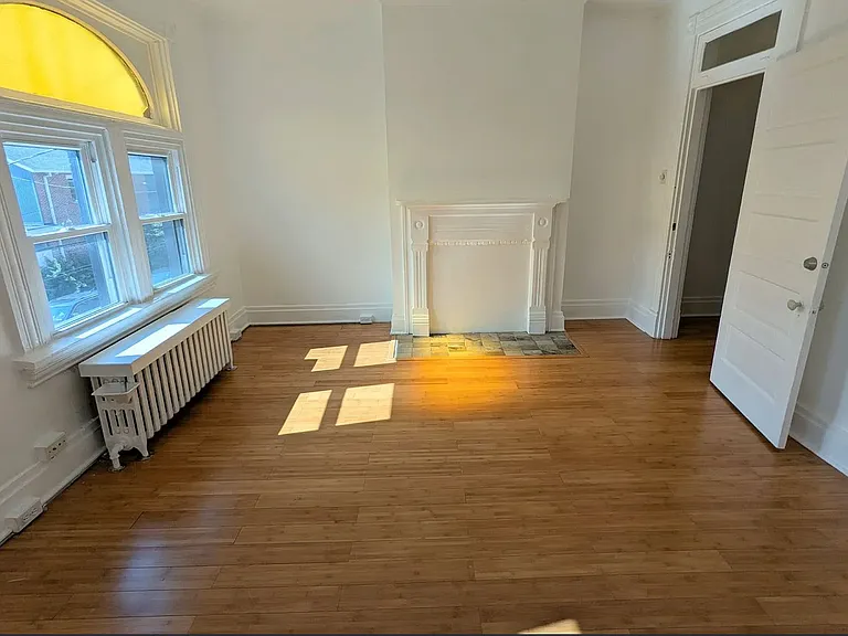2nd Floor Front Bedroom _ flooded with light, especially beautiful because of the antique stained glass yellow arched transom window, good sized closet and pristine hearth & fireplace