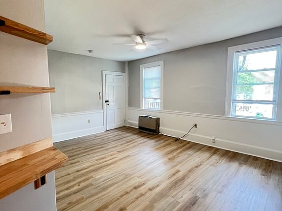 View of living room and entrance from the kitchen - offers new LVP flooring, energy efficient windows and ceiling fan