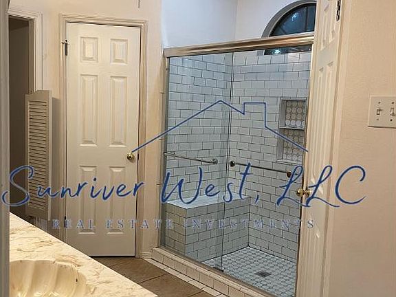 Primary bathroom with dual closets and updated tile shower