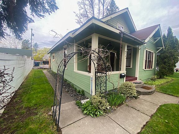 Front view of home and walkway to garage and alley access parking area