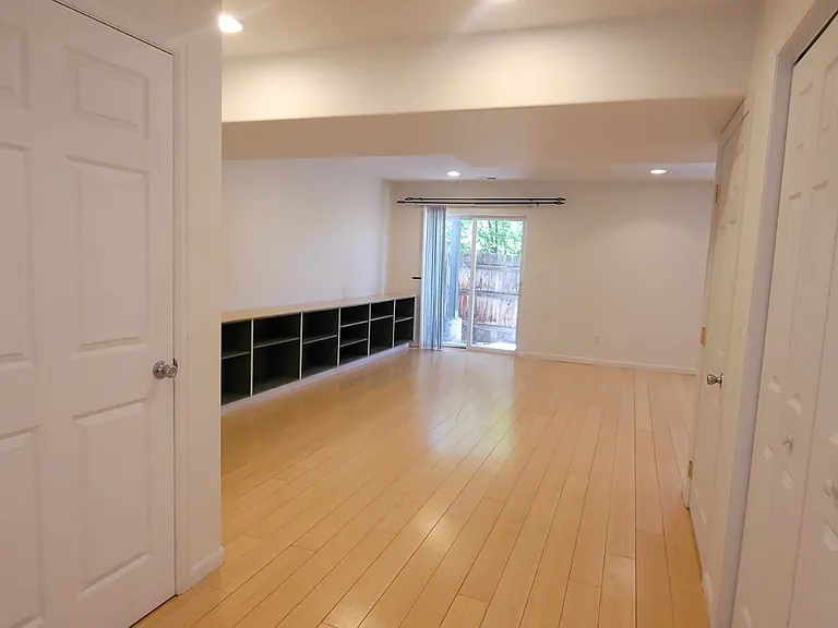 Mechanical room on the left and storage closets on the right. Long bookshelves going the walk-out fenced yard.