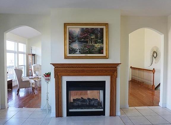 View from the Hearth/Breakfast Room into the Great Room with see-through gas fireplace. . Notice the arched doorways.