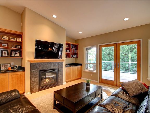 Open living space with vaulted ceilings, gas fireplace, surrounded by custom built-ins.