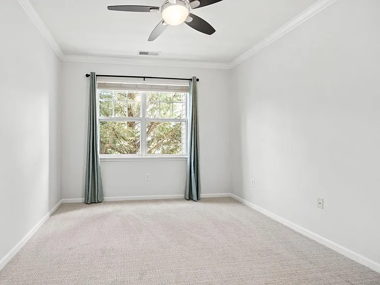 Freshly painted guest bedroom with new curtain rod. New carpet and new remote ceiling fan.