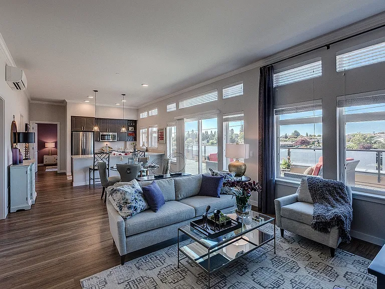 Our open living room and kitchen space includes a counter-level breakfast bar, large windows with ample natural light, and beautiful hard-wood style flooring.