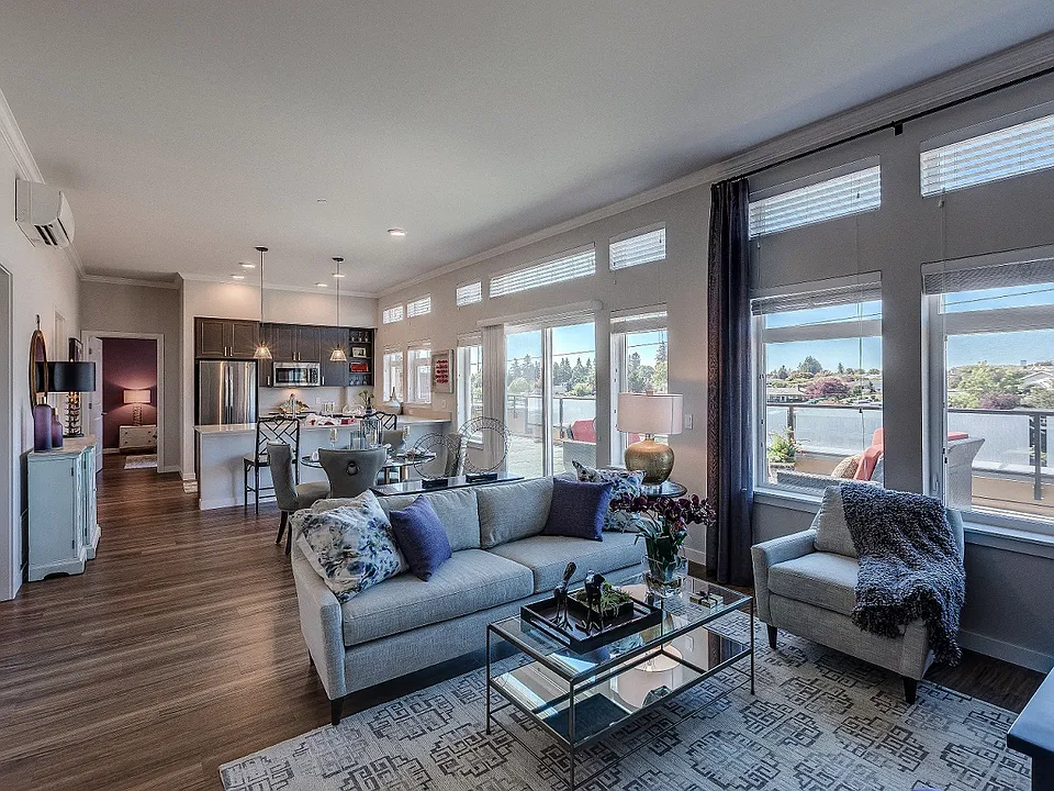 Our open living room and kitchen space includes a counter-level breakfast bar, large windows with ample natural light, and beautiful hard-wood style flooring.