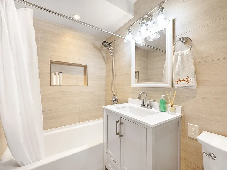 A beautiful designed bathroom with a bright mirror,fresh towels,and whole white docor for a clean spa-like feel.