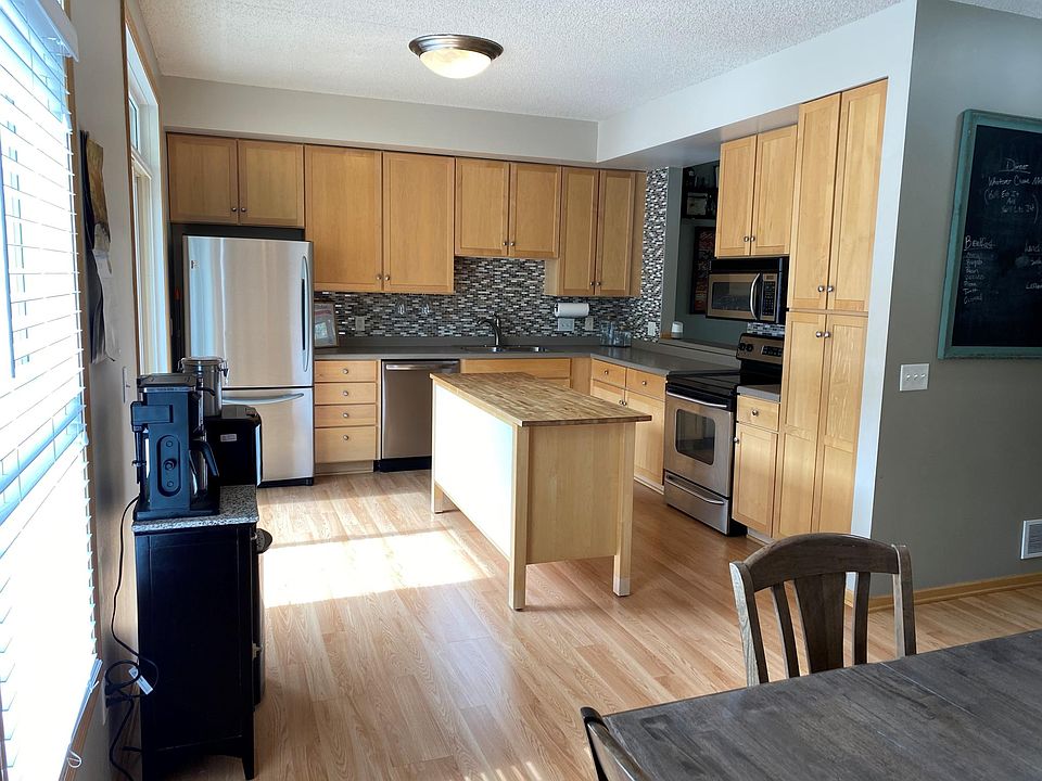 Beautiful open kitchen with upgraded appliances and custom glass tile backsplash and large center island for additional surface space and storage.