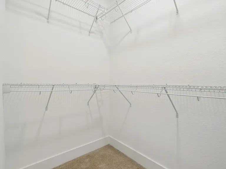 Spacious walk-in closet with multiple wire shelves, perfect for organized storage.