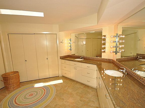 Spacious Master bathroom with skylights, double sinks, granite countertops with mosaic backsplash, t