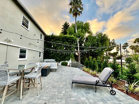 4 person hot tub, gas fire pit, outdoor seating, and outdoor dining table nestled in the canyon, with string lights and gorgeous views