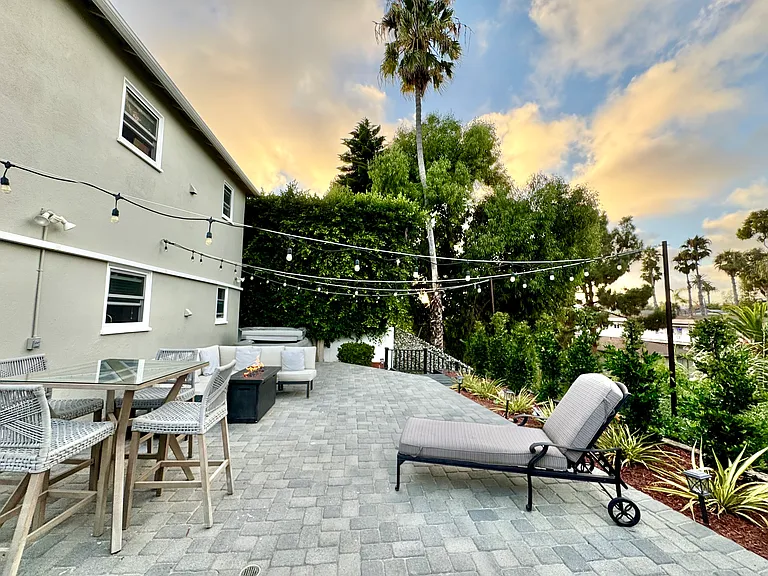 4 person hot tub, gas fire pit, outdoor seating, and outdoor dining table nestled in the canyon, with string lights and gorgeous views