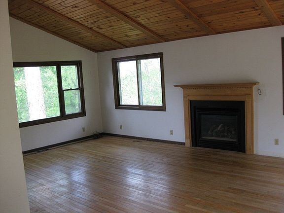 The living room features vaulted ceilings and fireplace