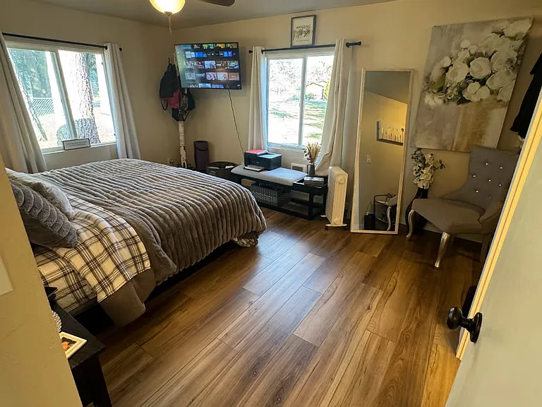 Master bedroom - view 3 - showing entrance, fan and windows. (Note: current renter is willing to sell both televisions, if requested).