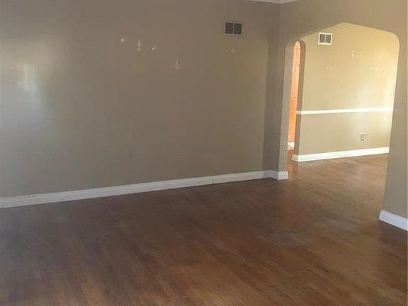 Arched doorway in living room leading into dining room.