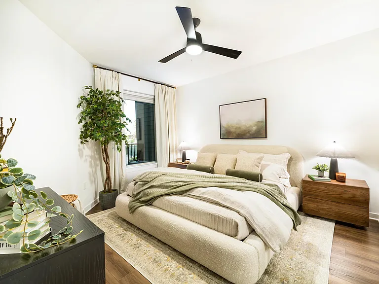 A light-filled bedroom at Modera Nations features wide-plank flooring and a calming layout, with Downtown Nashville just moments from home.