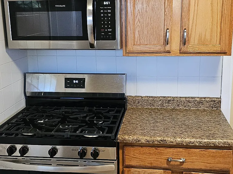 Kitchen w tile backsplash and new appliances