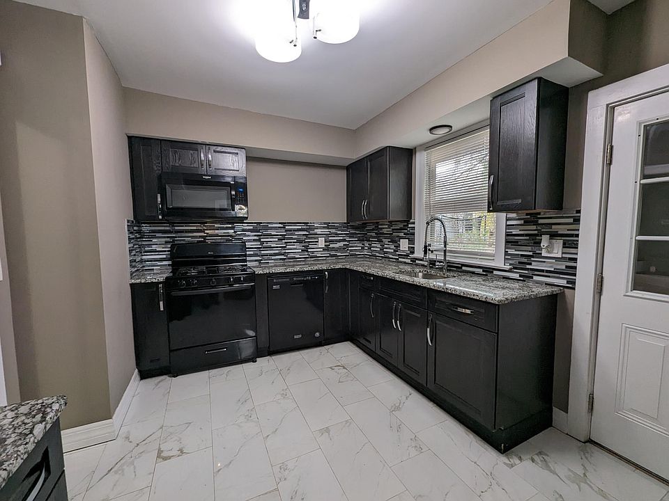 Kitchen with window above sink, dishwasher, stove and microwave with vent