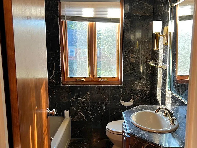 Luxuriously decorated, dark-brown marble hall bathroom. The jetted tub provides a massage at the push of a button.