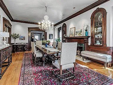 dining room with a table that seats 12, a large chandelier, a large gas-burning fireplace, built-in cabinets and pocket doors