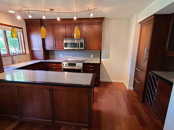 Kitchen with microwave, oven and dishwasher, storage for wine and bottles, extra sink