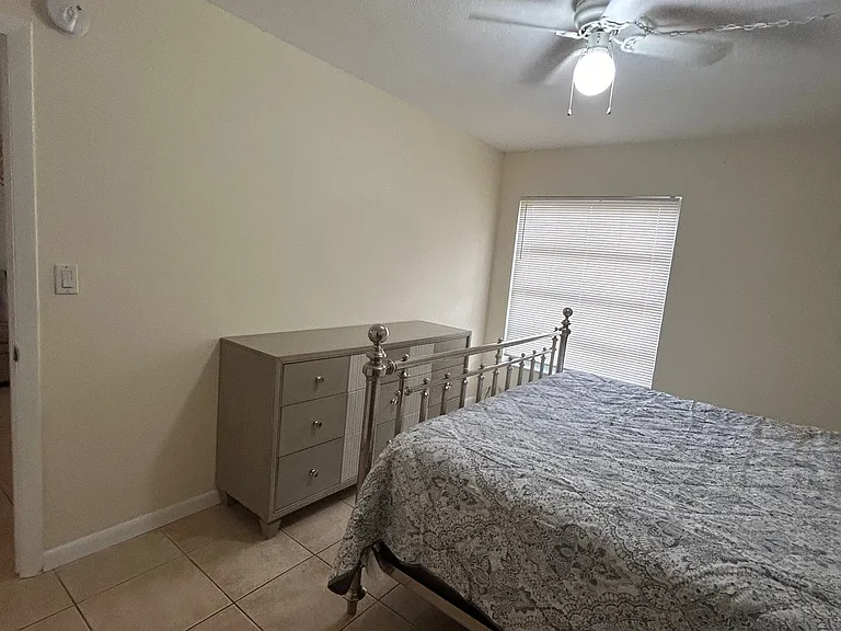 master room with king bed and dresser, two night stands, desk