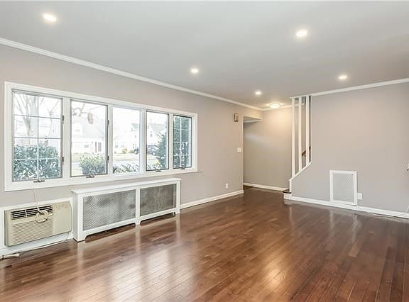 Another view of bright and airy living room with recessed lighting