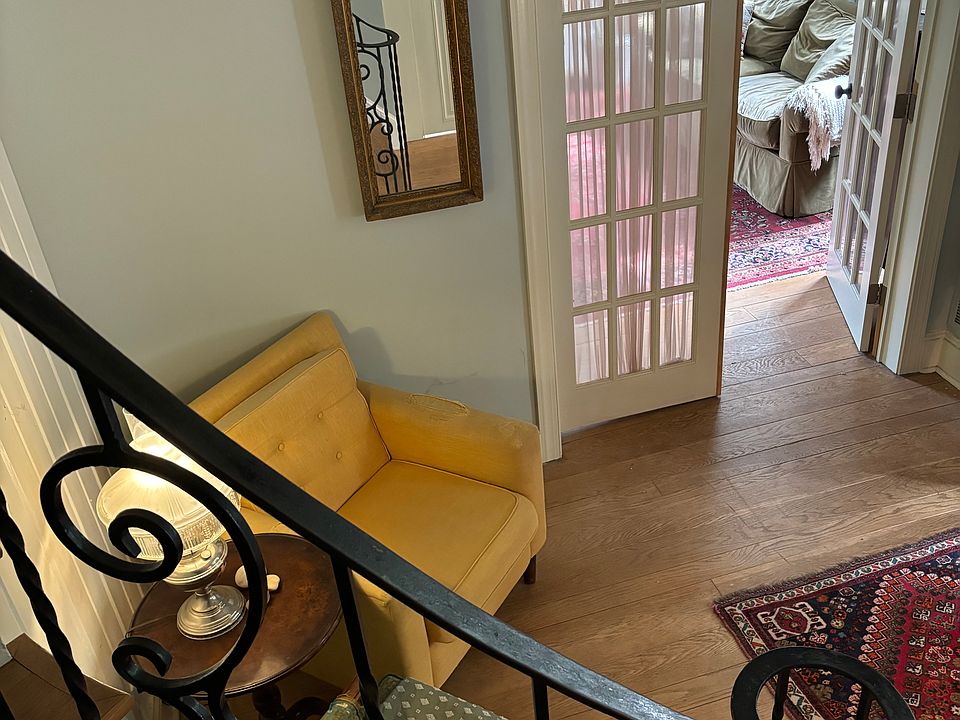 View of the foyer and peek into the living room as you descend the unique curved staircase