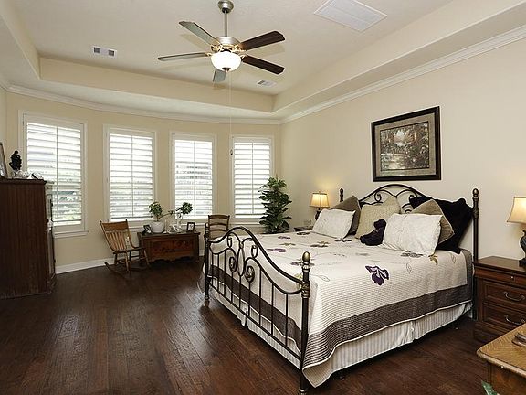 The first floor master has a wonderful view of the backyard and has hardwoods and plantation shutter