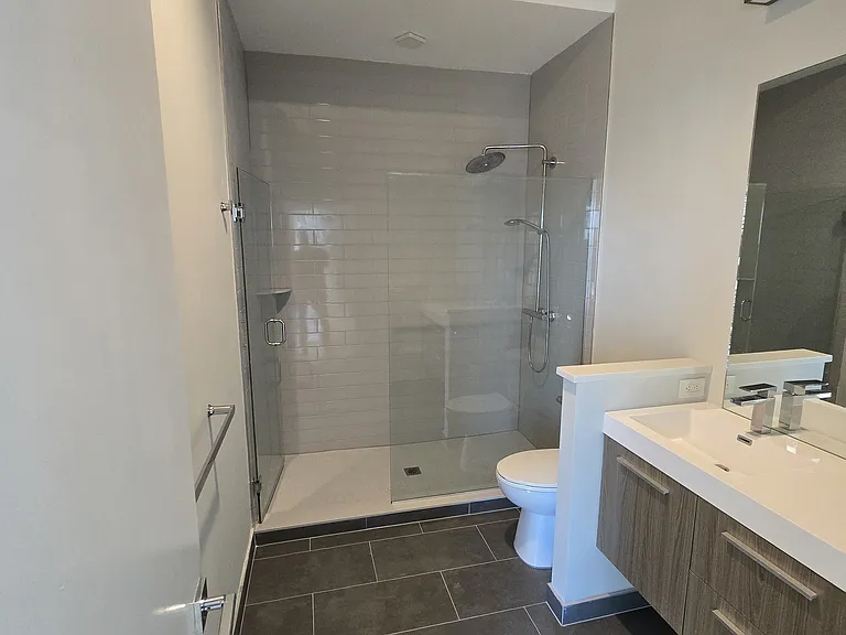 Newly updated primary bedroom ensuite bathroom with walk-in shower and double sinks with quartz countertops (current photo).