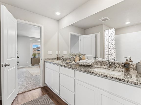 The master bathroom has a dual sink vanity.