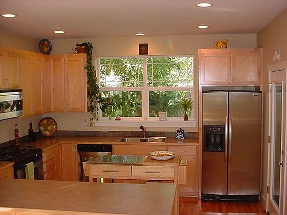Room for all the cooks with stainless gas appliances, pantry and hardwood.