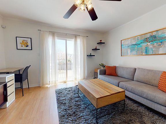 Living room area with large TV and desk - coffee table can be raised to work or eat from the couch