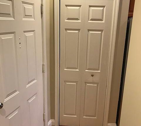 entryway displaying apartment door and kitchen pantry