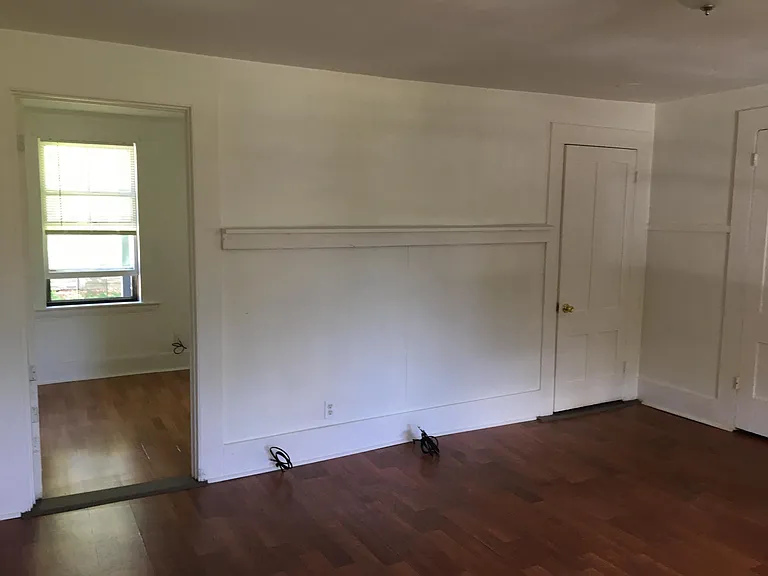 Living room. Left door goes into the second bedroom. the right closed door is into the bathroom.