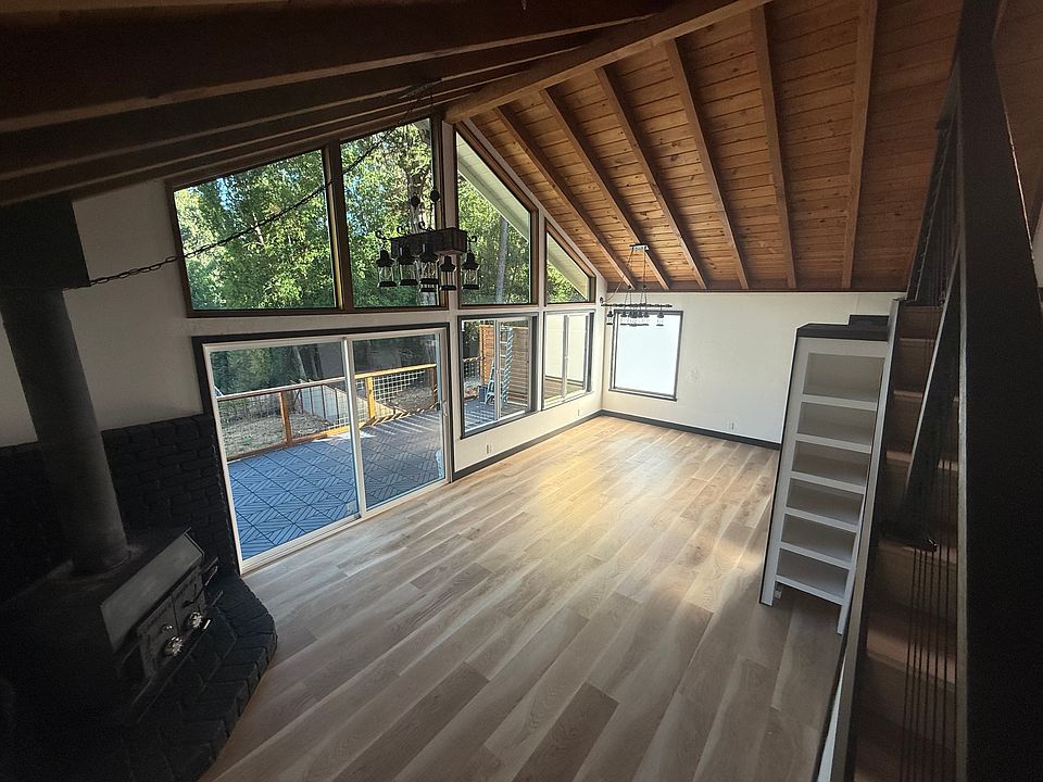 view from stairs looking down into living room. Notice cast iron wood burning fireplace towards the left.