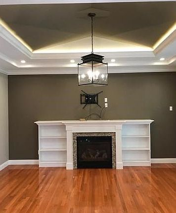Great Room features an indirect coffered lit ceiling, fine crown appointment, a stately mantel, and built-in bookcases.