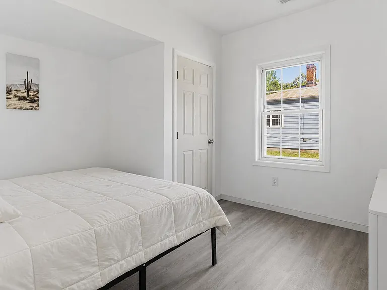 Private bedroom with a furnished bed, wide window for natural light, and closet door for convenient storage.