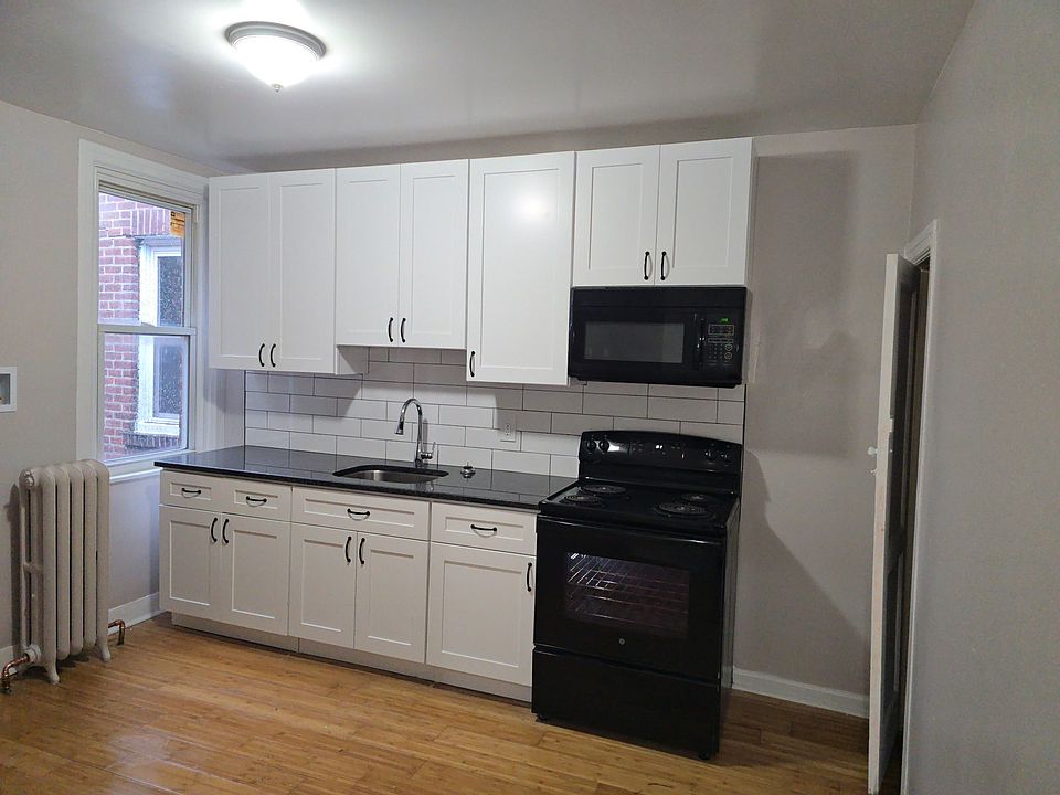 The fridge and stackable washer and dryer are located to the left of the window. There is also lots of space for a table and chairs