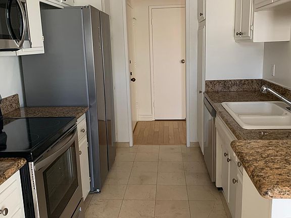 Kitchen with new stainless appliances, Crema Marfil marble floor and granite countertops.