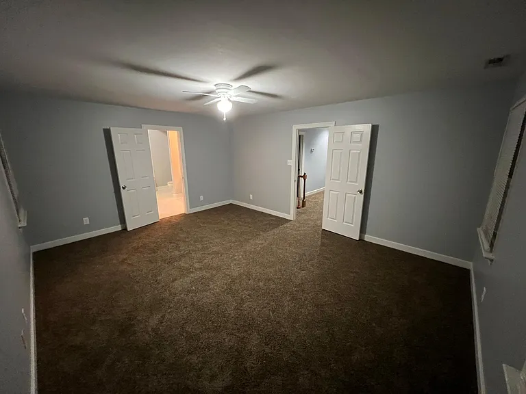 Photo of master bedroom, door on the right is to the hallway, door pictured to the left is the door to the master bathroom with walk in closet