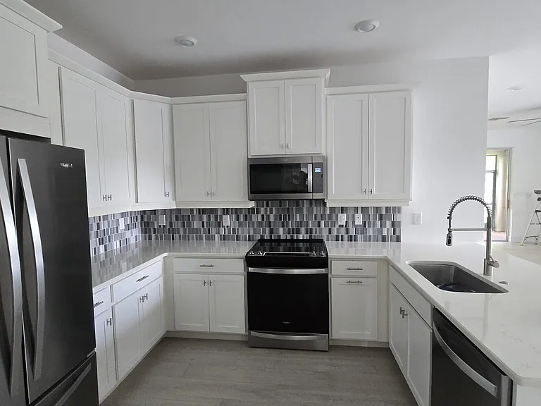 Custom cabinetry, beautifully accented by modern hardware and a striking tile backsplash.