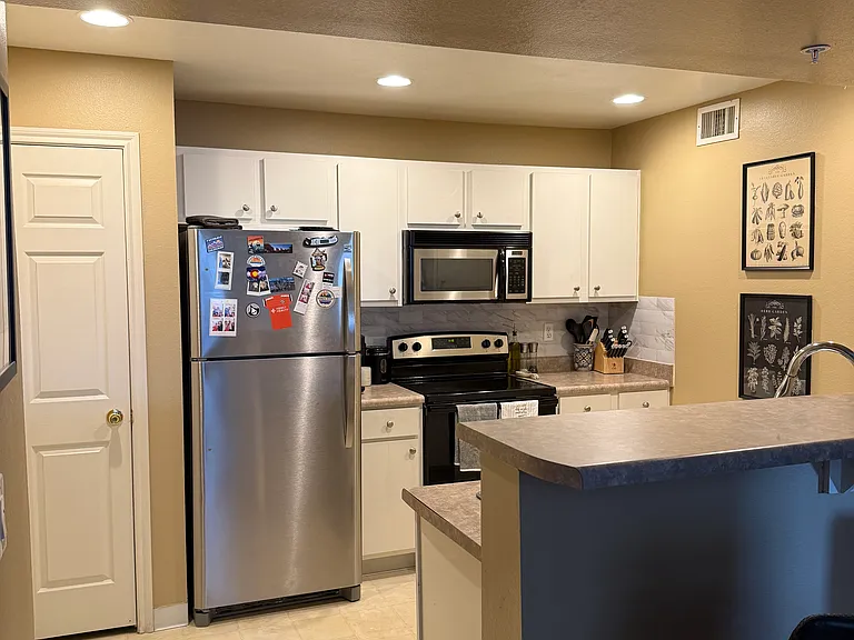 View standing in the family room looking at the kitchen. That door next to the fridge is the pantry