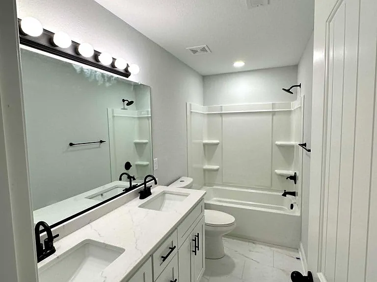 Bathroom #2 also has a double vanity and modern bathtub with shelving space.