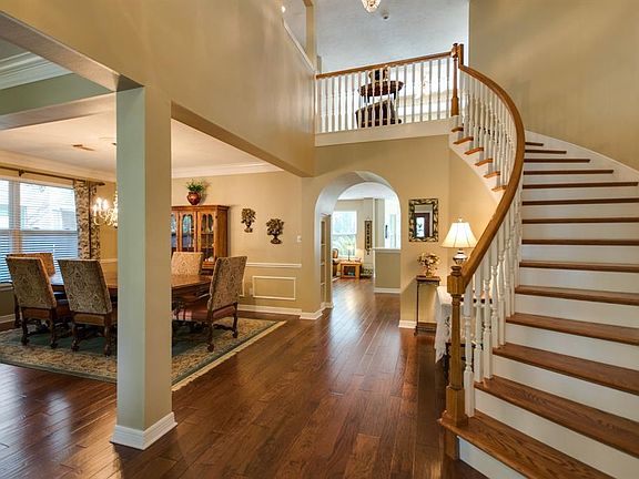 Elegant two story foyer feature spiral staircase and warm hardwoods.