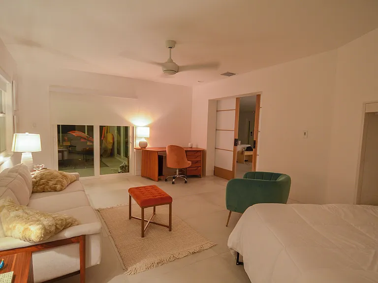 Sunroom with coach, murphy bed and desk. Easy access via sliding glass door to the screened in porch